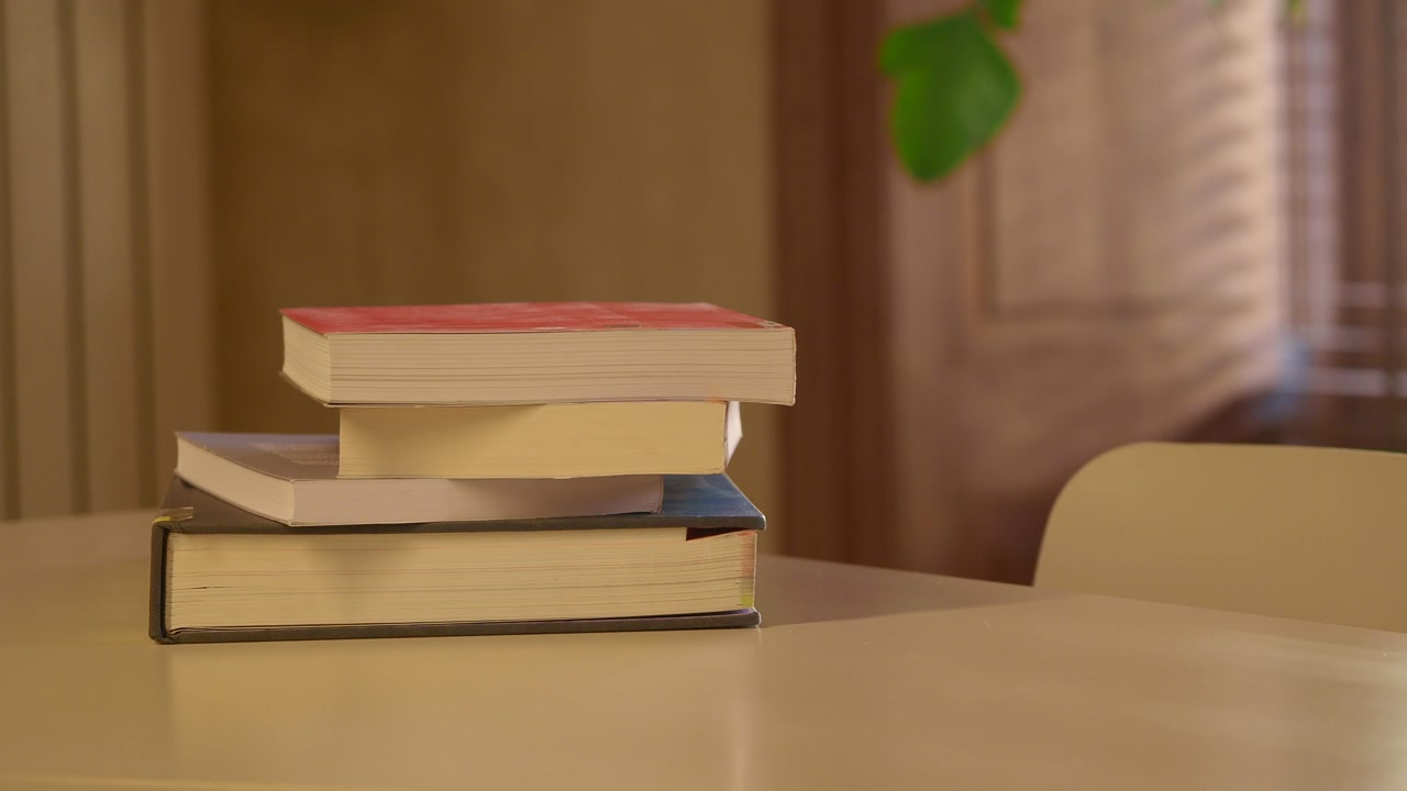 Camera Zooms In on a Stack of Books on a Table