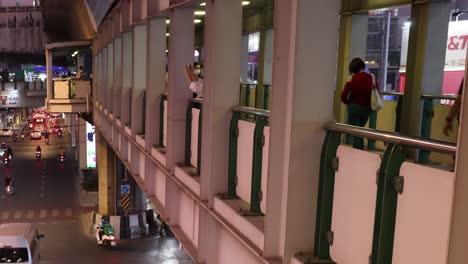 people walking on an overpass at night