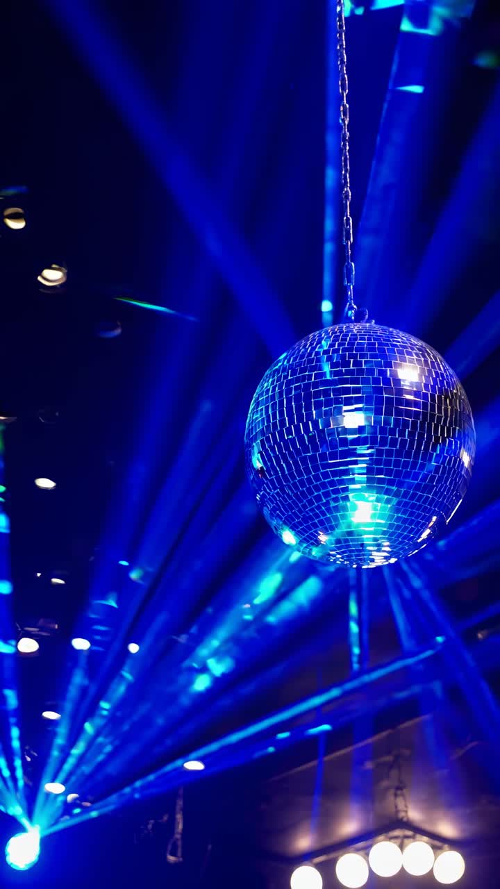 Ripresa dal basso di una palla da discoteca con luci e raggi blu, per creare un'atmosfera vivace da party video