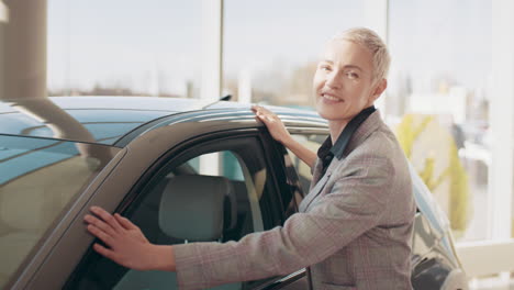 mujer examinando un coche nuevo en una sala de exposiciones