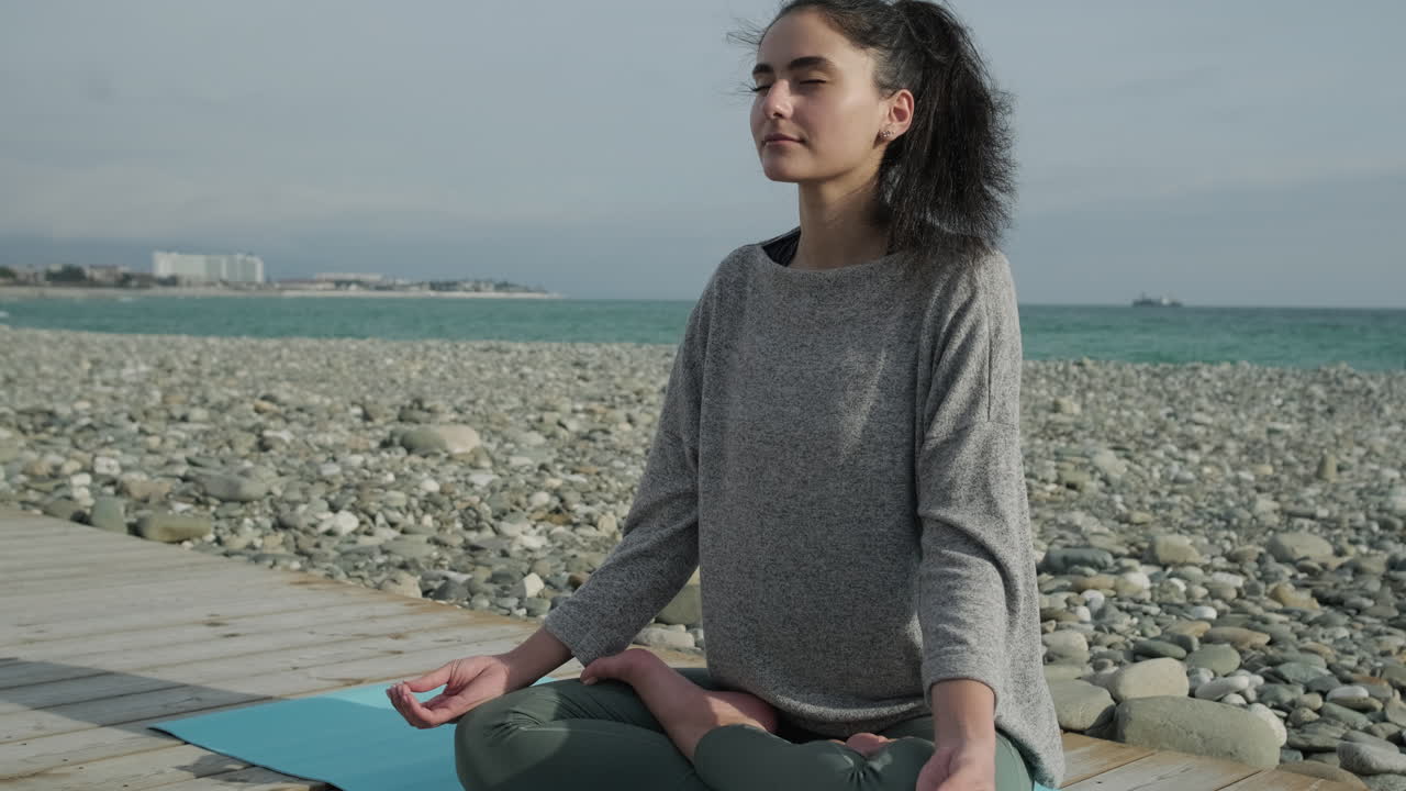 mujer meditando en la playa