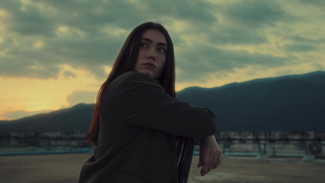 Jovem Mulher Sentada em Cadeira Contemplando o Pôr do Sol nas Montanhas