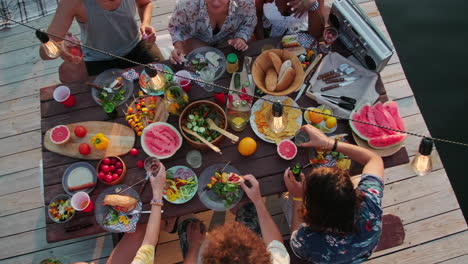 top down of people having dinner party at table on lake pier