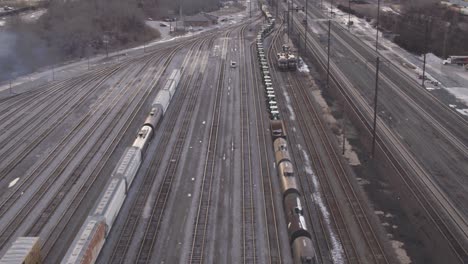 Aerial-view-of-a-long-train-of-rail-cars-pulling-away-from-a-train-yard