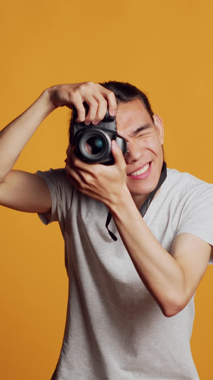 Video verticale: giovane fotografo professionista che usa una fotocamera reflex digitale