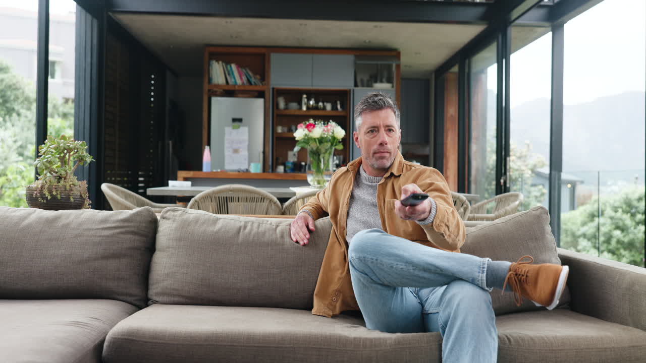 Et lykkeligt par slapper af i sofaen og ser TV derhjemme