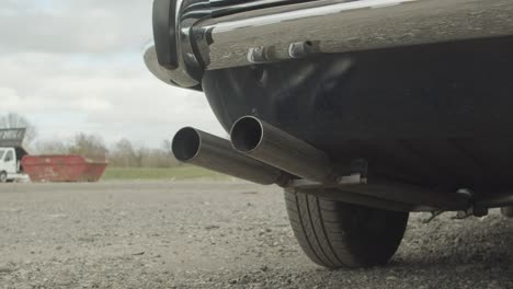 A-close-up-of-the-exhaust-of-a-classic-car-while-the-engine-revs