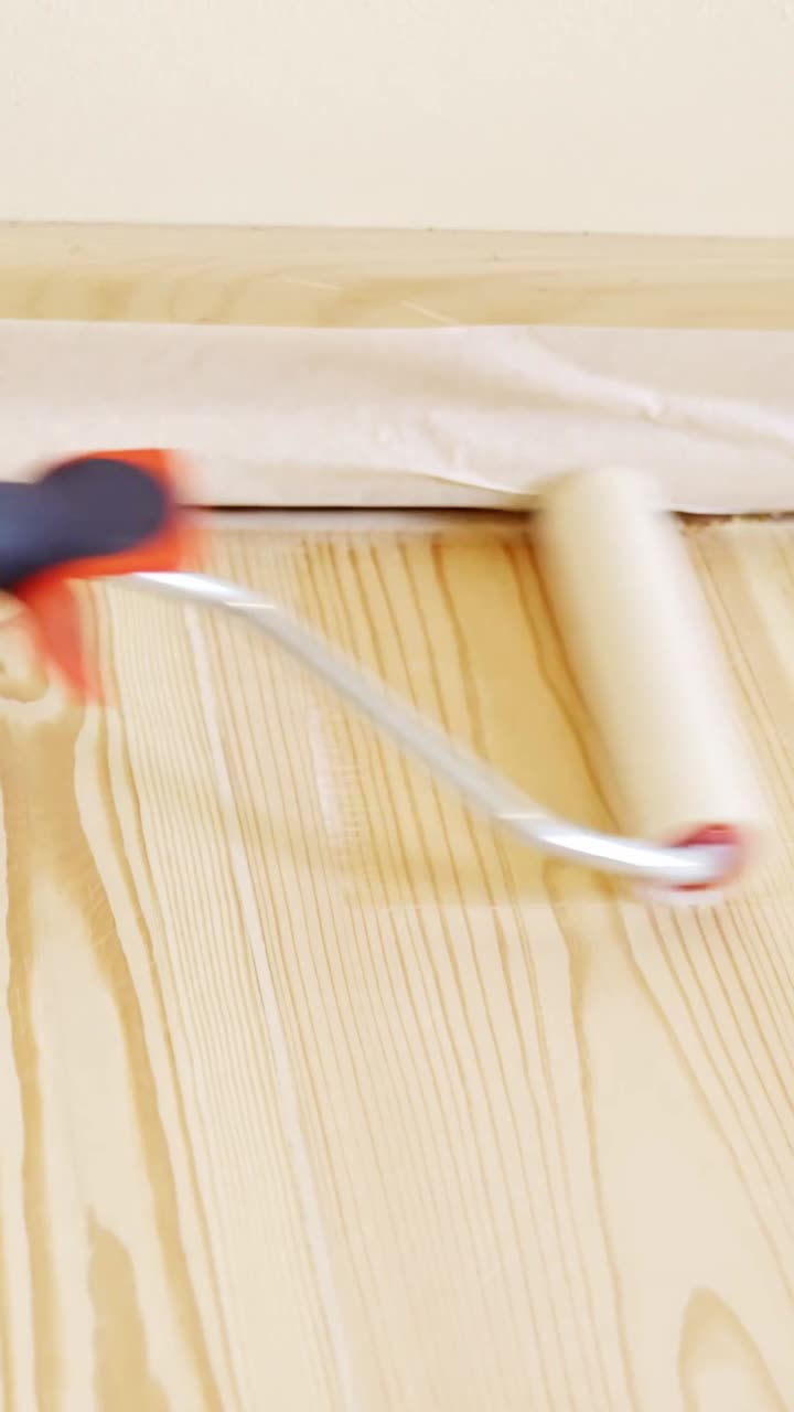 Vertical shot of priming a hardwood floor for a DIY home project