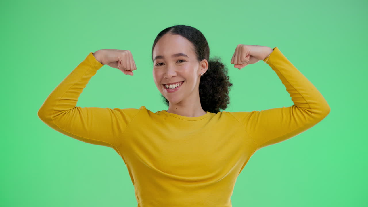 Woman flexing muscles with confidence on green screen