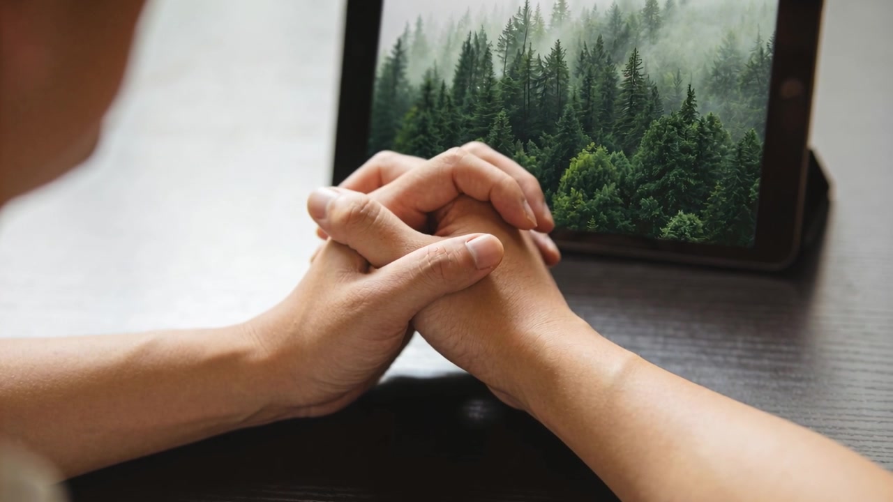 Starting with finger shift, holding hands, pair seeking comfort at home, tablet showing mist forest