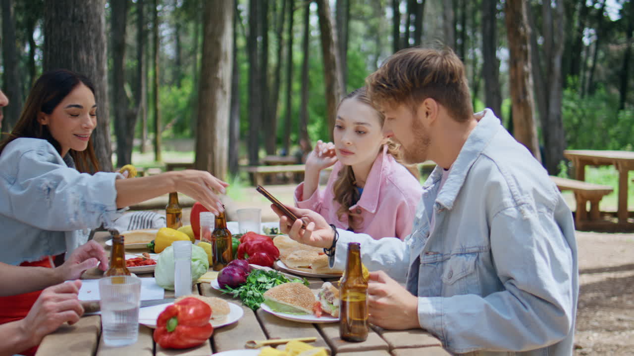 Carefree youngsters meeting forest eating food closeup. Happy friends picnic