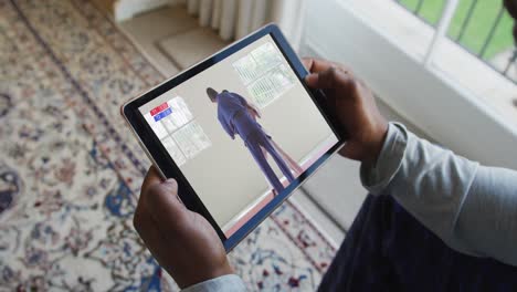 Composite-of-man-sitting-at-home-watching-judo-match-on-tablet