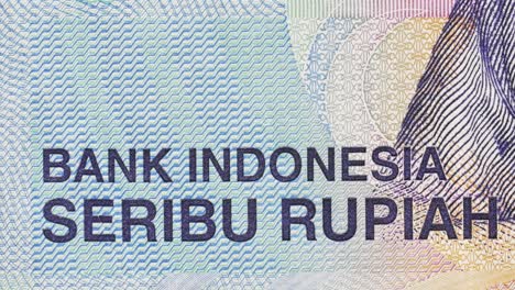 Close-up pan highlighting “Bank Indonesia” and “Seribu Rupiah” text with guilloche patterns