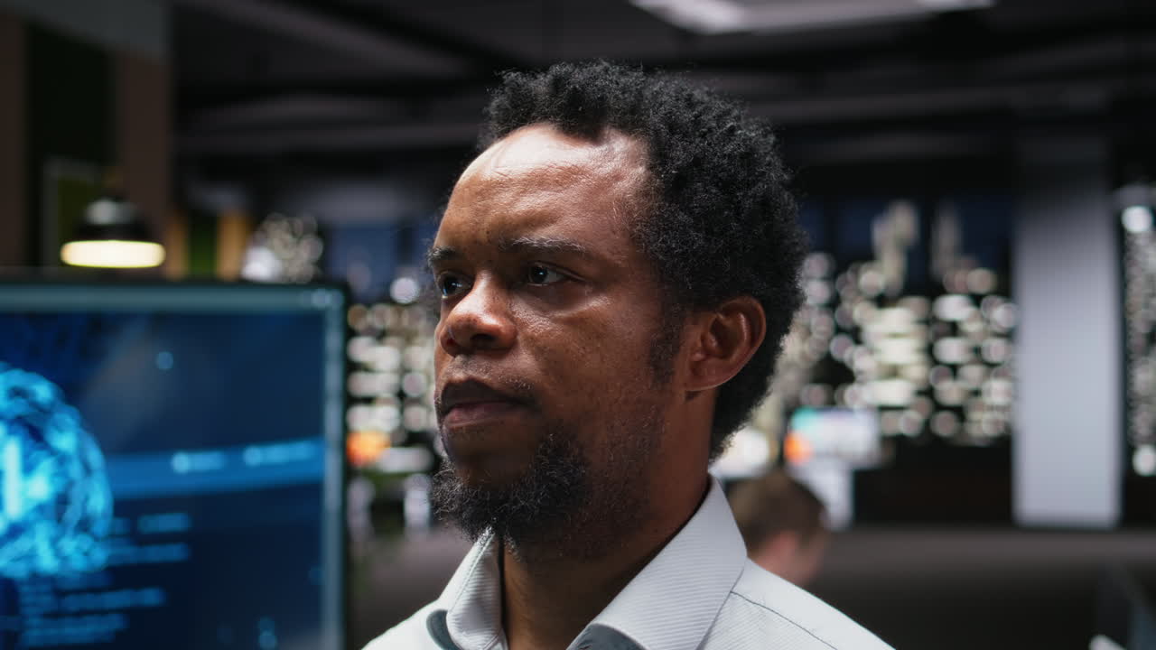 Afroamerikanischer Mann blickt nachdenklich in einem modernen Büro