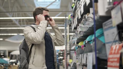 man trying on sunglasses in a sporting goods store