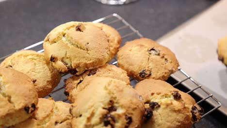 hand-held shot of a baker transferring cooked scones onto a cooling tray to set