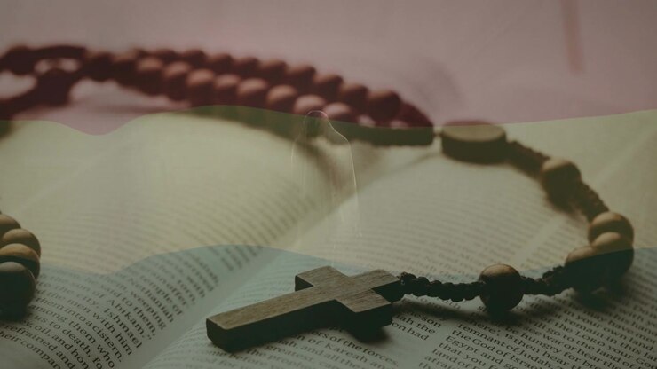 Wooden rosary resting on open book, subtle lighting shifting focus, evoking calm religious mood
