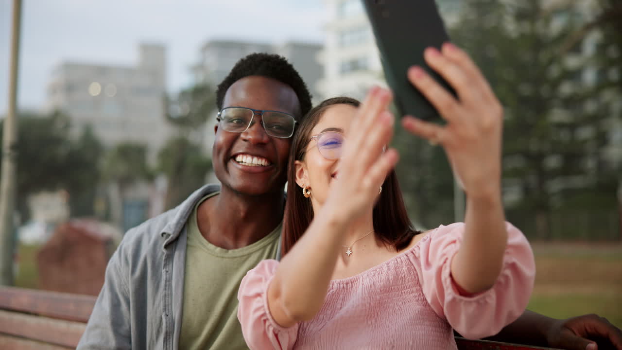 Felice coppia interrazziale che si scatta un selfie al parco