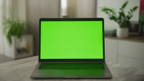 static video of an open laptop computer with a green screen chromakey on it