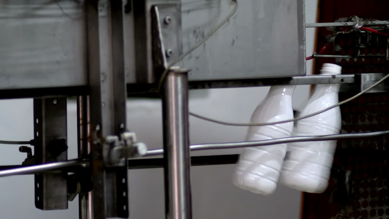 imágenes de un fabricante de botellas de plástico, las botellas son empujadas hacia adelante para su posterior procesamiento