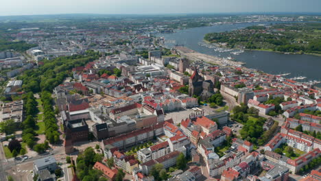 Vorwärts-Fliegen-über-Der-Stadt.-Luftaufnahme-Der-Stadt-Am-Fluss-Oder-In-Der-Meeresbucht.-Nach-Unten-Geneigte-Aufnahmen-Des-Neuen-Marktplatzes-Mit-Giebelhäusern-Und-Der-Marienkirche