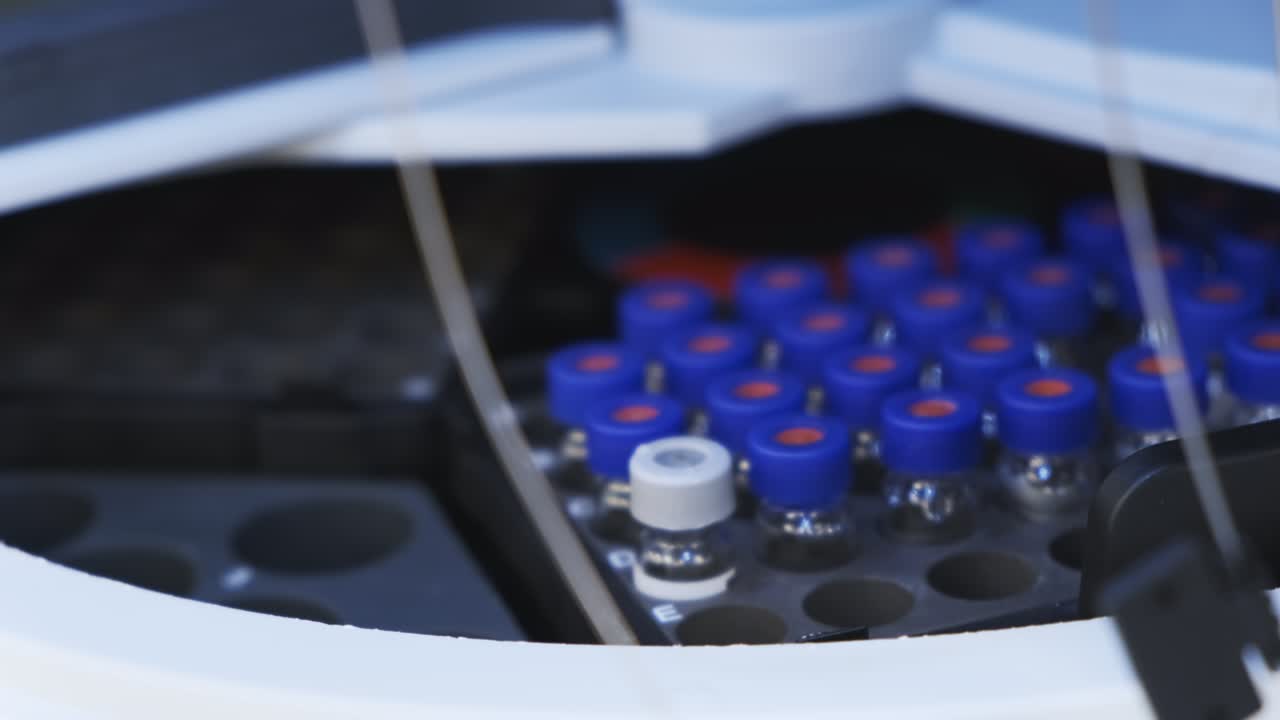 el asistente pone el vial con la vacuna en el muestreador automático de hplc