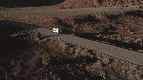 Vista-Aérea-De-Una-Camioneta-Que-Atraviesa-Con-Gracia-La-Carretera-A-Través-De-Indian-Creek,-Un-Famoso-Destino-De-Escalada-En-Roca-En-Utah,-EE.-UU.,-Que-Combina-Aventura-Y-Libertad-En-La-Carretera-Abierta.