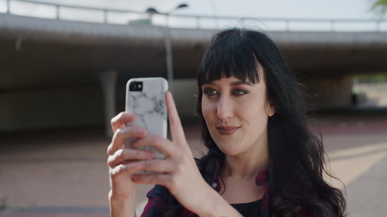 retrato de una mujer joven usando un teléfono inteligente posando tomando una foto selfie sonriendo feliz disfrutando de la tecnología de la cámara del teléfono móvil serie de personas reales