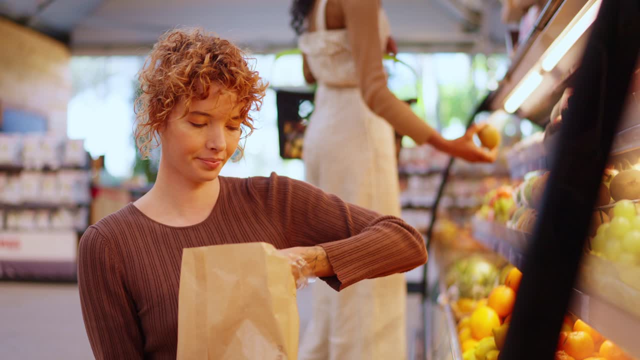 Mujer comprando naranjas en una tienda de comestibles