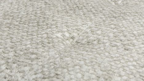 camera slowly zooms in on fluffy wool texture on seat cushion in photography studio