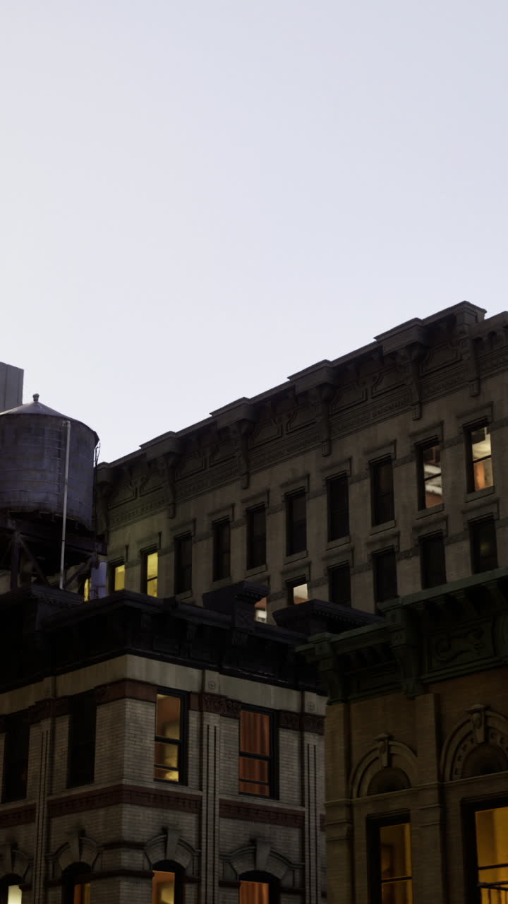 As twilight descends buildings in the city come alive with glowing windows