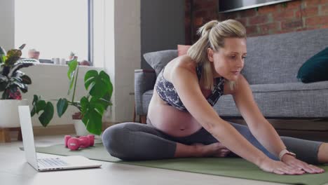 mujer embarazada activa viendo videos de ejercicio prenatal en línea