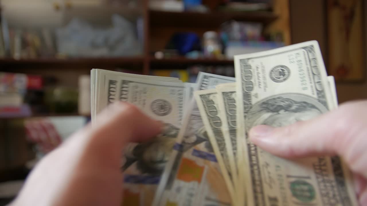 cuenta el montón de dólares.