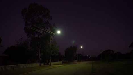 streetlights illuminating empty road with warm glow at night time past dusk