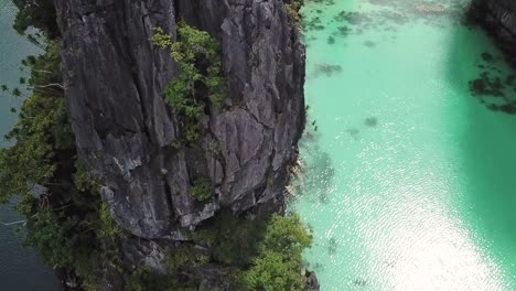 Incline-Hacia-Arriba-La-Vista-Aérea-Del-Acantilado-Que-Divide-Dos-Majestuosa-Laguna-Tropical-En-El-Nido,-Isla-De-Palawan,-Filipinas