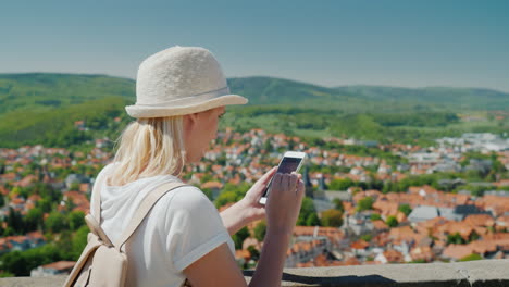 turista con smartphone por encima de los tejados alemanes