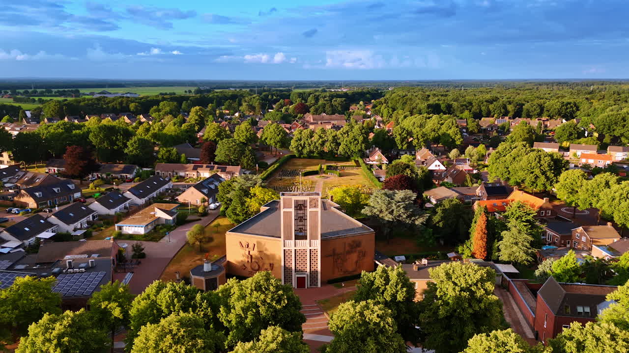 Scenery of the green residential area with an unusual church. Drone footage above Overloon in the Netherlands