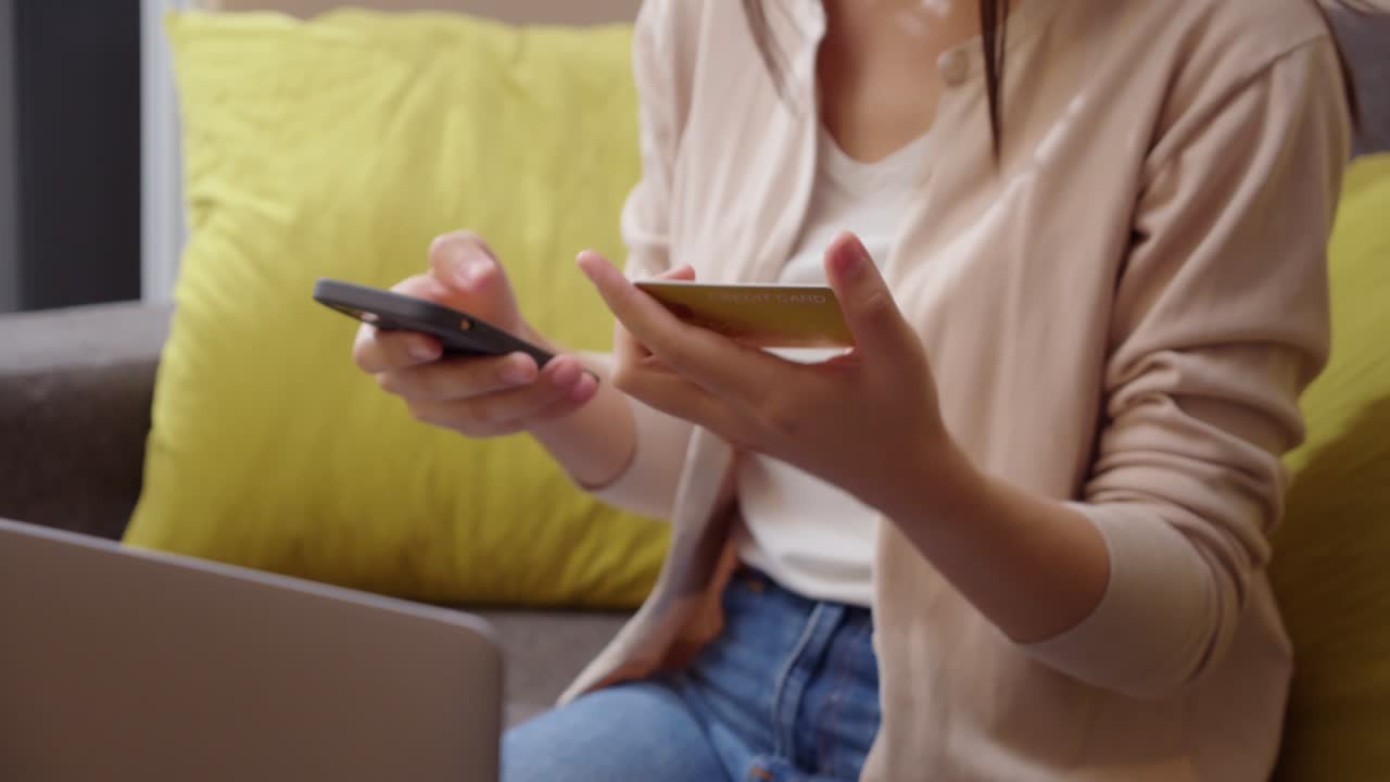 close up mujer con teléfono inteligente y tarjeta de crédito bancaria para compras en línea en el hogar. mujer comprando bienes o servicios en la tienda en línea. transacción o pago en línea. concepto moderno.