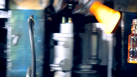 la masa de vidrio fundido se está transformando en botellas en forma