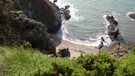 Scenic-Coastline-of-Scotland,-Lookout-POV-on-Hidden-Beach-Under-Steep-Cliffs-on-Sunny-Day