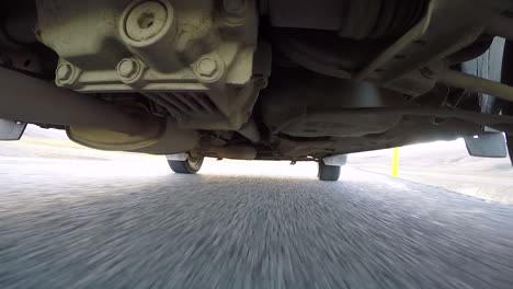 view from under a car while driving in iceland. road trip normal speed