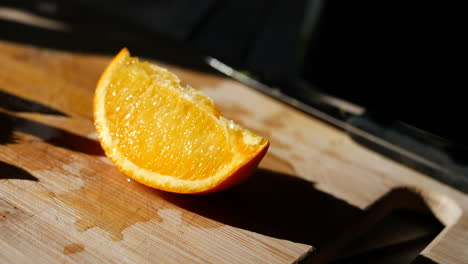 a colorful orange fruit slice on a cutting board in the sunlight for a healthy snack