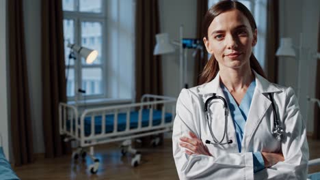 professional female doctor wearing lab coat and stethoscope stands confidently with crossed arms, exuding professionalism and expertise in a modern hospital room