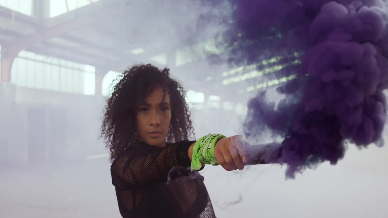 bailarina en un almacén vacío con una granada de humo
