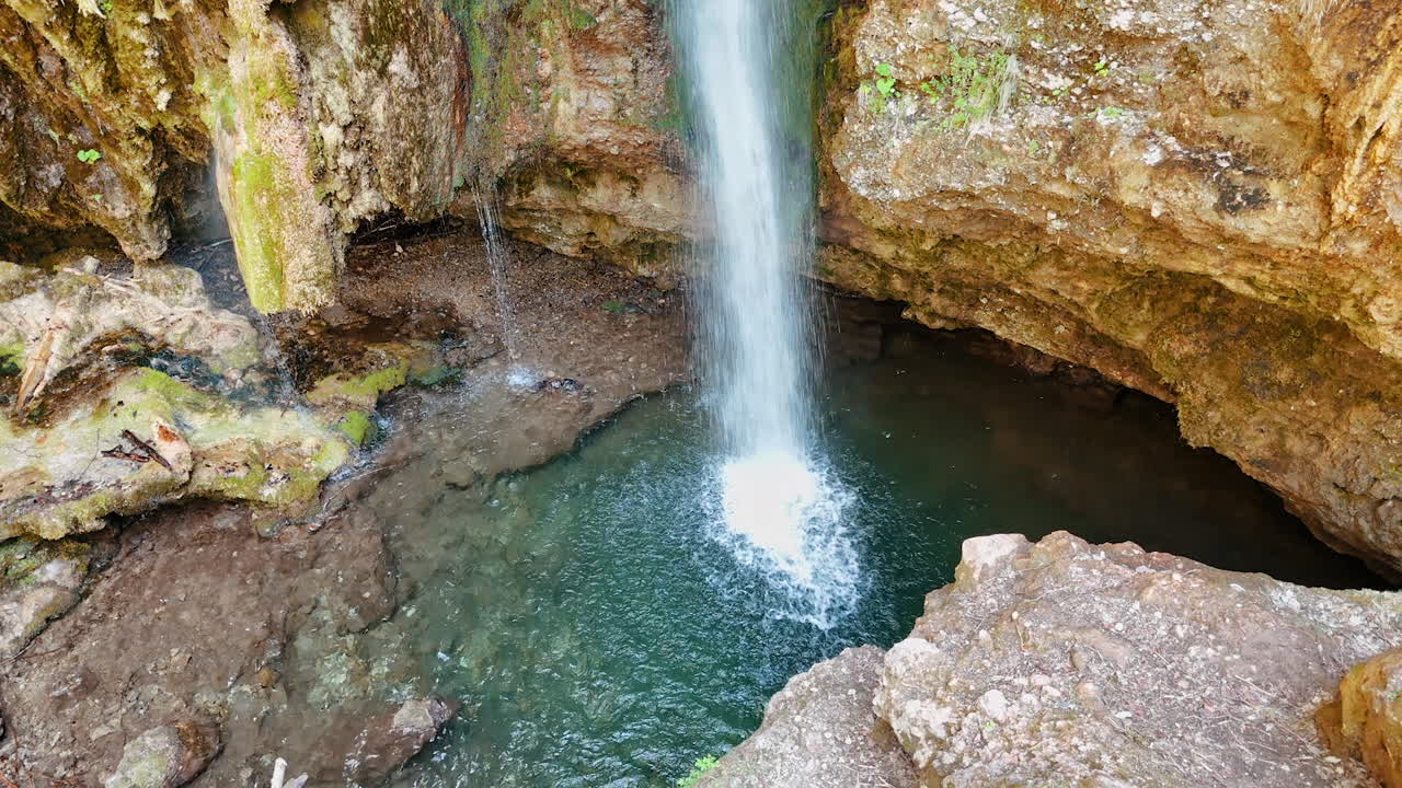 Water falls into the pond with crystal clear water. Beautiful sandstone rocks with cataract.