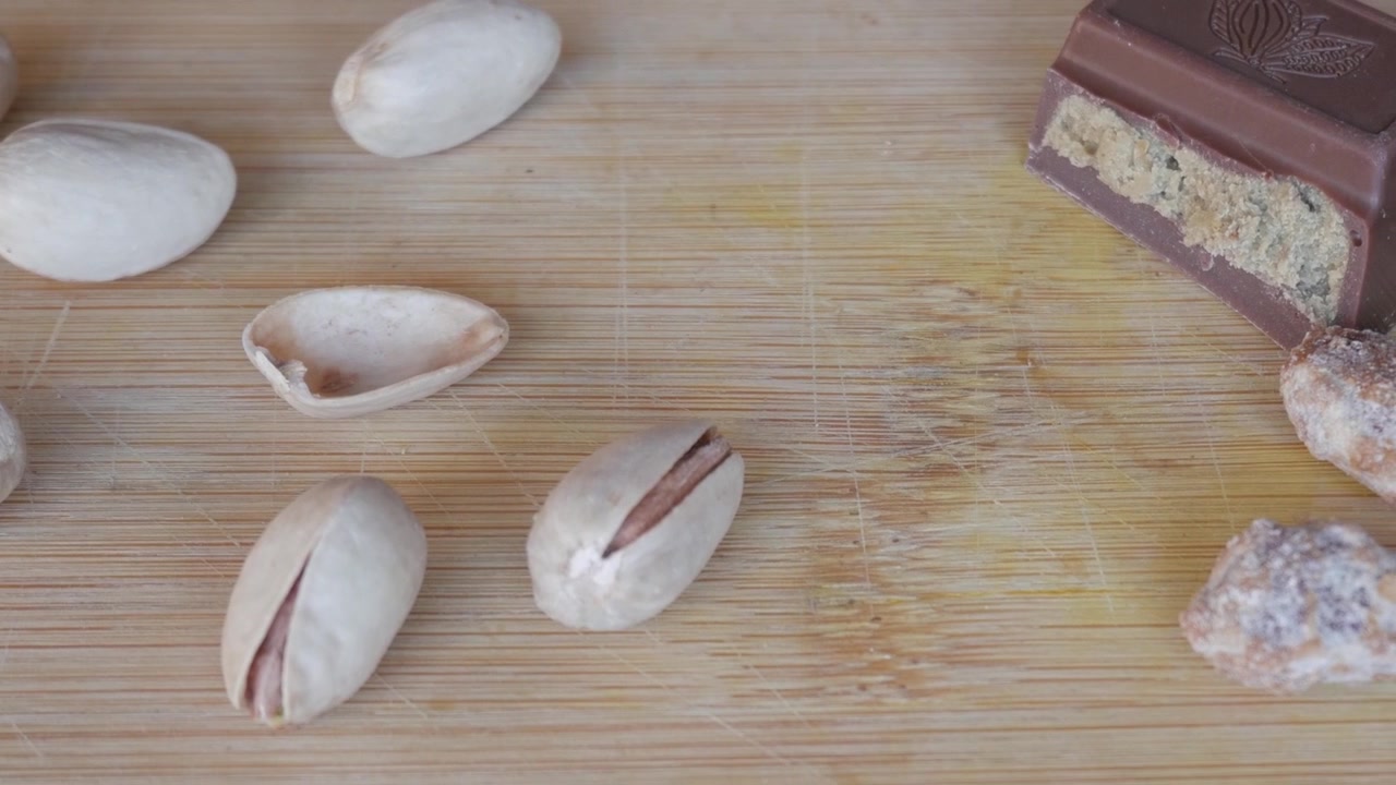 Pistachios and Dubai chocolate on a wooden surface, close-up view