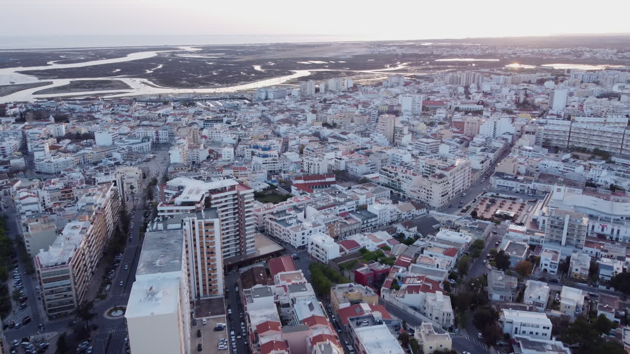 pôr do sol recuo aéreo cidade de faro com lagoa ria formosa ao fundo