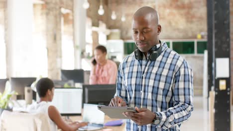 Portrait-of-happy-african-american-colleagues-with-tablet-in-creative-office-in-slow-motion