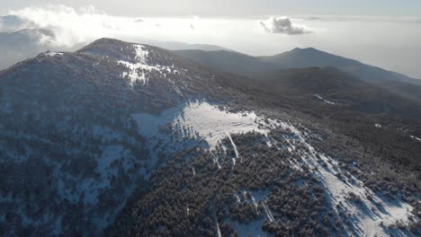 drone descending over snow cover mountain ridge winter sunny day