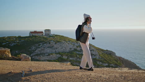 Turista-Alegre-Habla-Por-Teléfono-En-La-Cima-De-La-Montaña.-Chica-Emocionada-Compartiendo-Emociones-De-Viaje